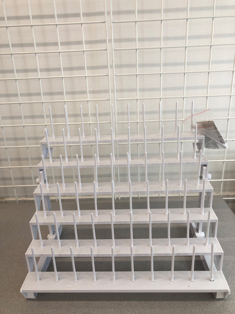 WHITE PLASTIC YARN SPOOL ORGANIZER.