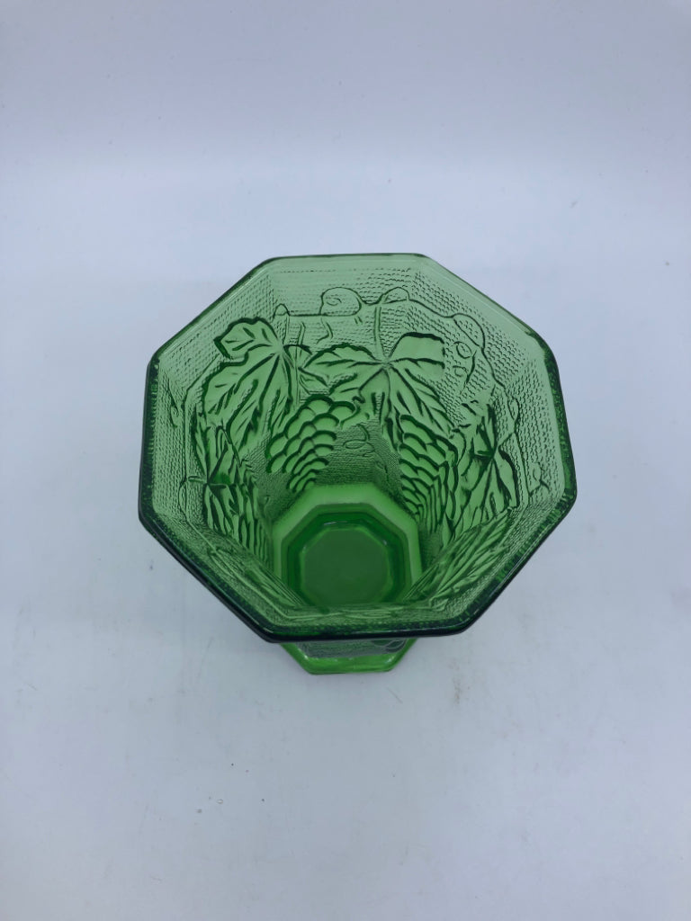 GREEN GLASS FOOTED  HEXAGON VASE W/ EMBOSSED GRAPES.