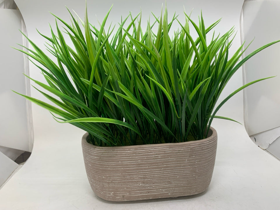 FAUX GRASS IN PLANTER.