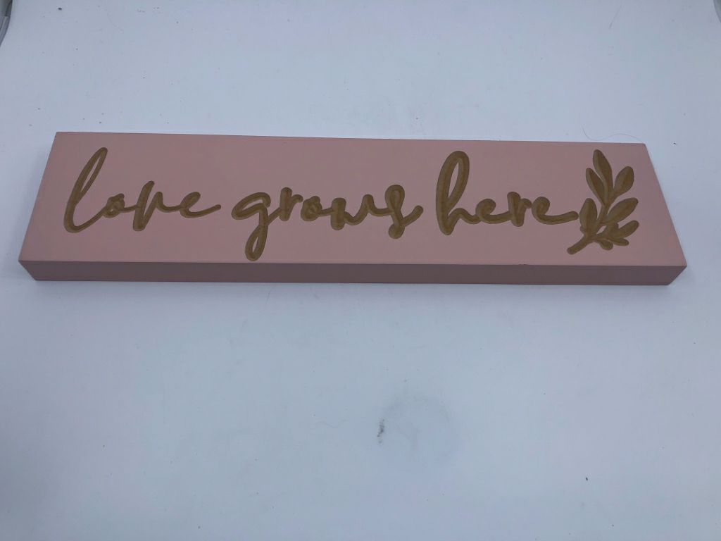 PINK "LOVE GROWS HERE" SIGN.