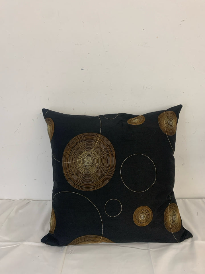 BLACK PILLOW WITH BROWN AND TAN CIRCLE.