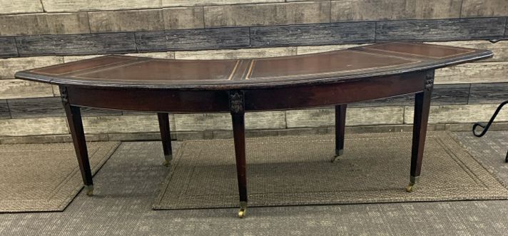 VTG DARK WOOD CRESCENT SHAPE COFFEE TABLE ON WHEELS.