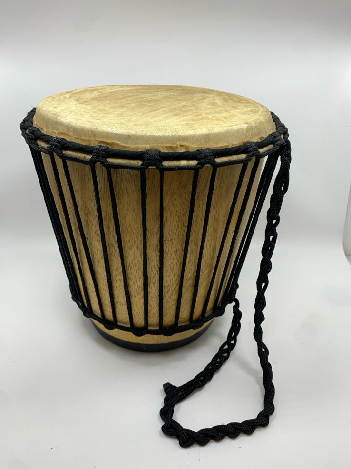 LIGHT COLORED DRUM W/BLACK ROPE.