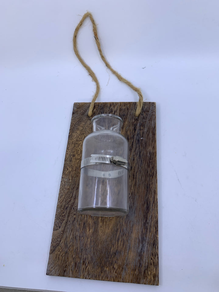GLASS BOTTLE VASE ON PLANK.