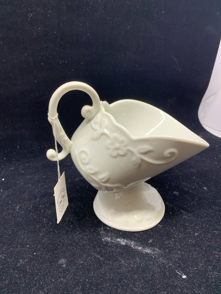 CREAM FOOTED FLORAL SCROLL EMBOSSED TILTED GRAVY BOAT.