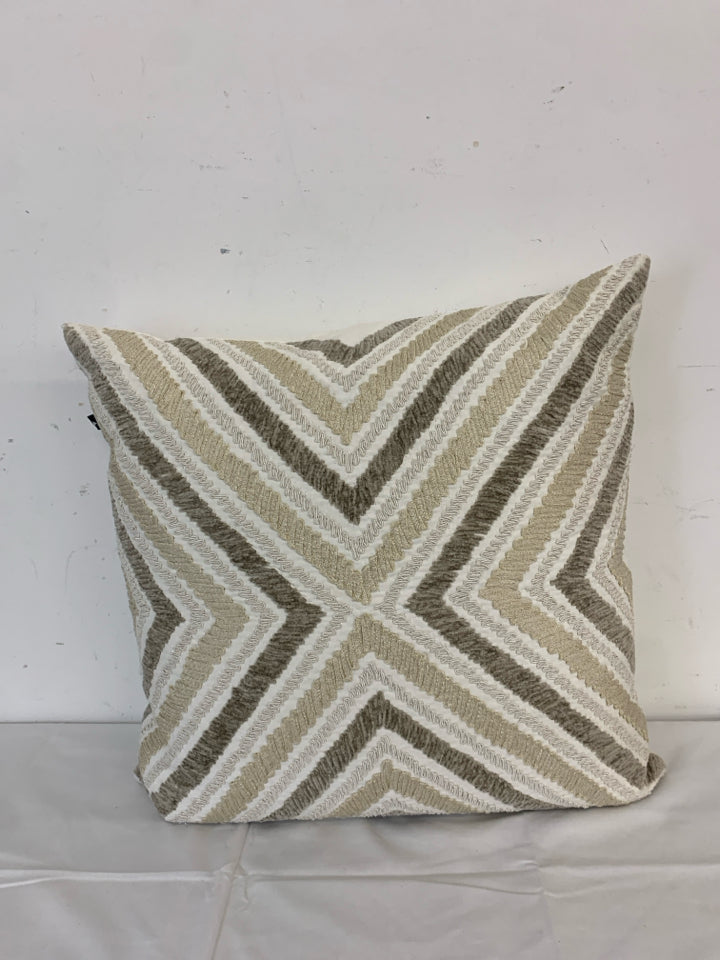 CREAM PILLOW W TAN AND BROWN CHEVRON PATTERN.