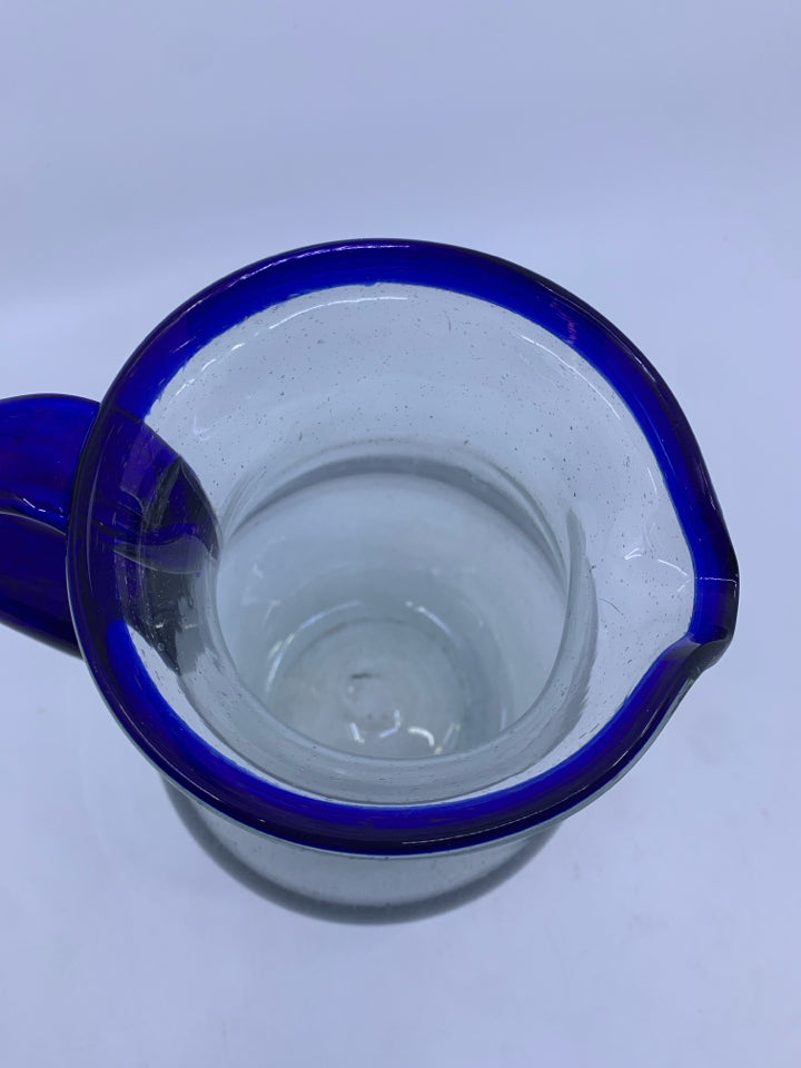 CLEAR GLASS PICTURE W/BLUE HANDLE AND RIM.