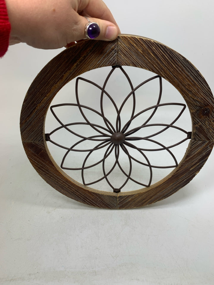 CIRCLE FRAME W/ METAL FLOWER IN CENTER.