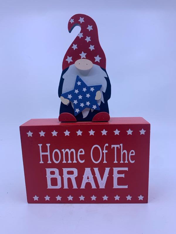 HOME OF THE BRAVE RED SIGN W/ GNOME HOLDING STAR.