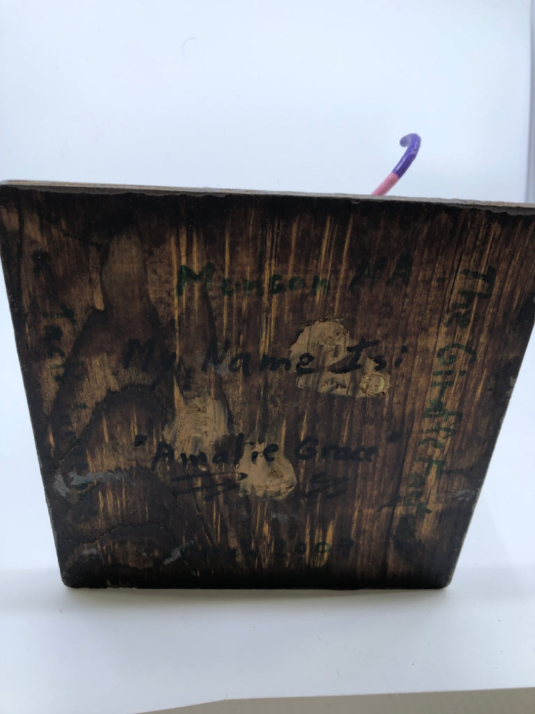 PINK AND PURPLE GIRAFFE ON WOOD STAND.