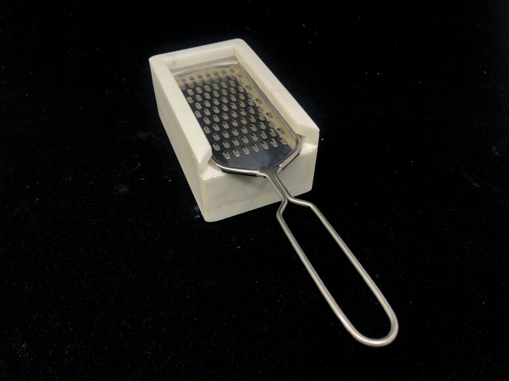 CHEESE GRATER W HANDLE IN HEAVY WHITE MARBLE HOLDER.