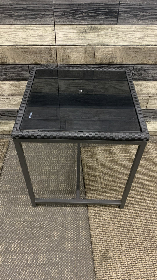 BLACK METAL OUTDOOR SIDE TABLE W/WOVEN EDGE AND TEMPERED GLASS TOP.