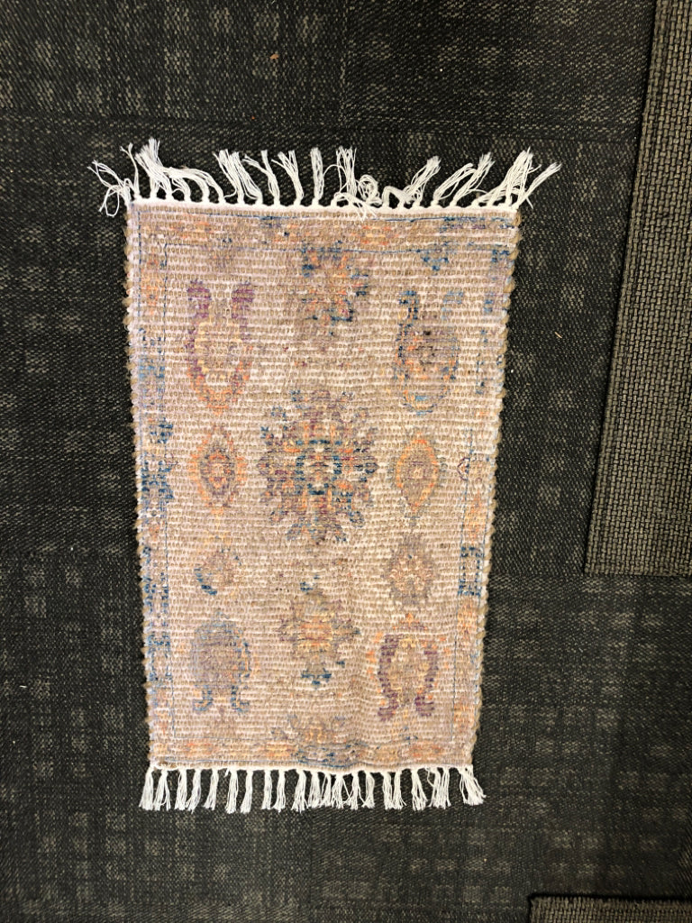 SMALL MULTI-COLORED WOVEN RUG W/ FRINGE ON ENDS.
