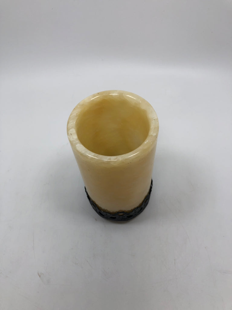 CREAM RESIN TEA LIGHT HOLDER ON BLACK METAL BASE.