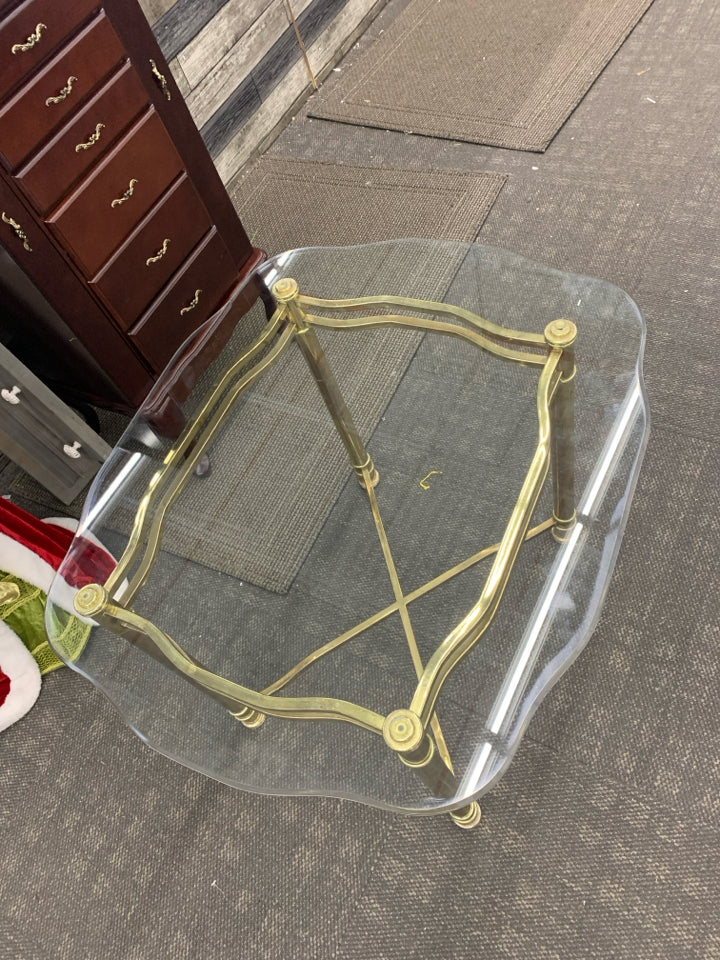 GOLD TABLE W/GLASS TOP AND X BASE.
