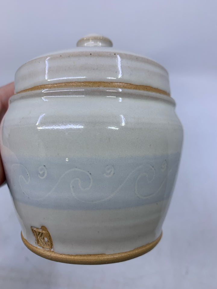 CREAM SHORT POTTERY CANISTER W/ LIGHT BLUE BAND WHITE WAVE OUTLINES.