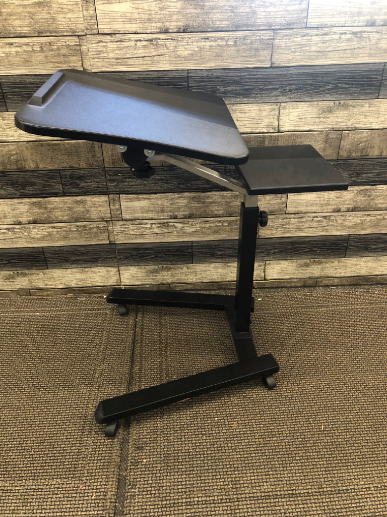 BLACK PLASTIC COMPUTER DESK ON WHEELS.