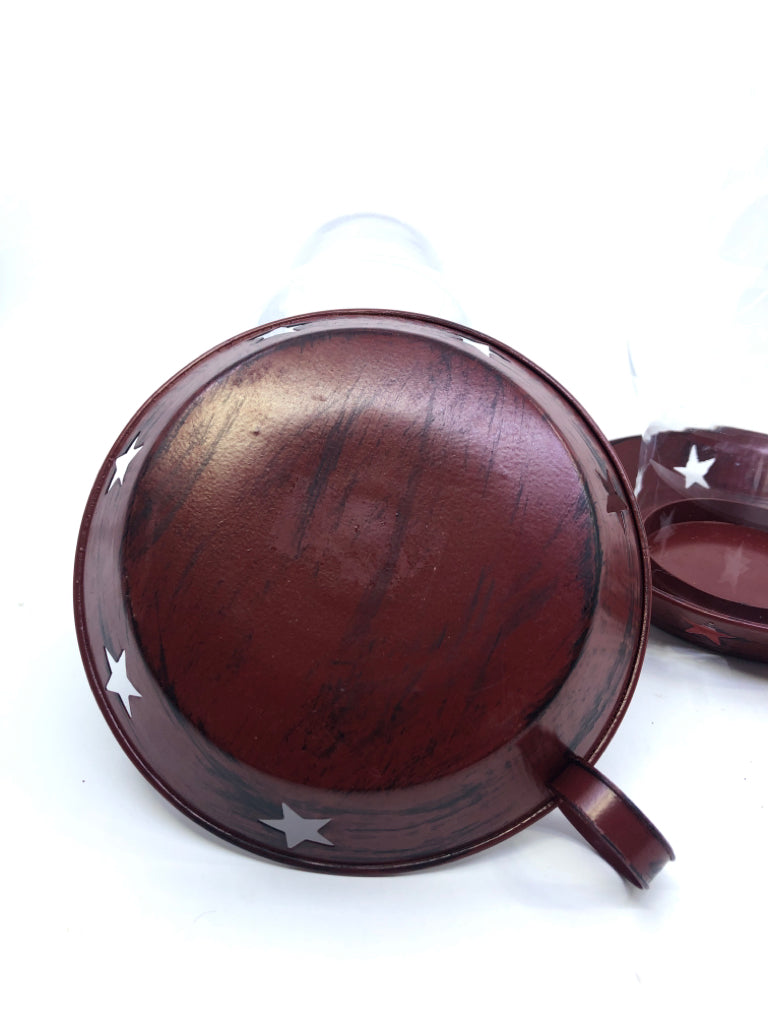 2 PRIMITIVE RED METAL PLATES W/GLASS HURRICANE CANDLE HOLDERS.