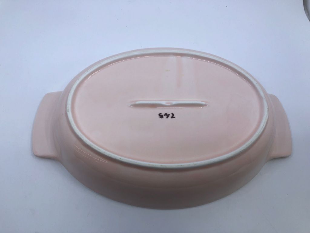 LIGHT PINK OVAL BAKING DISH W WHITE FLORAL AND HANDLES.