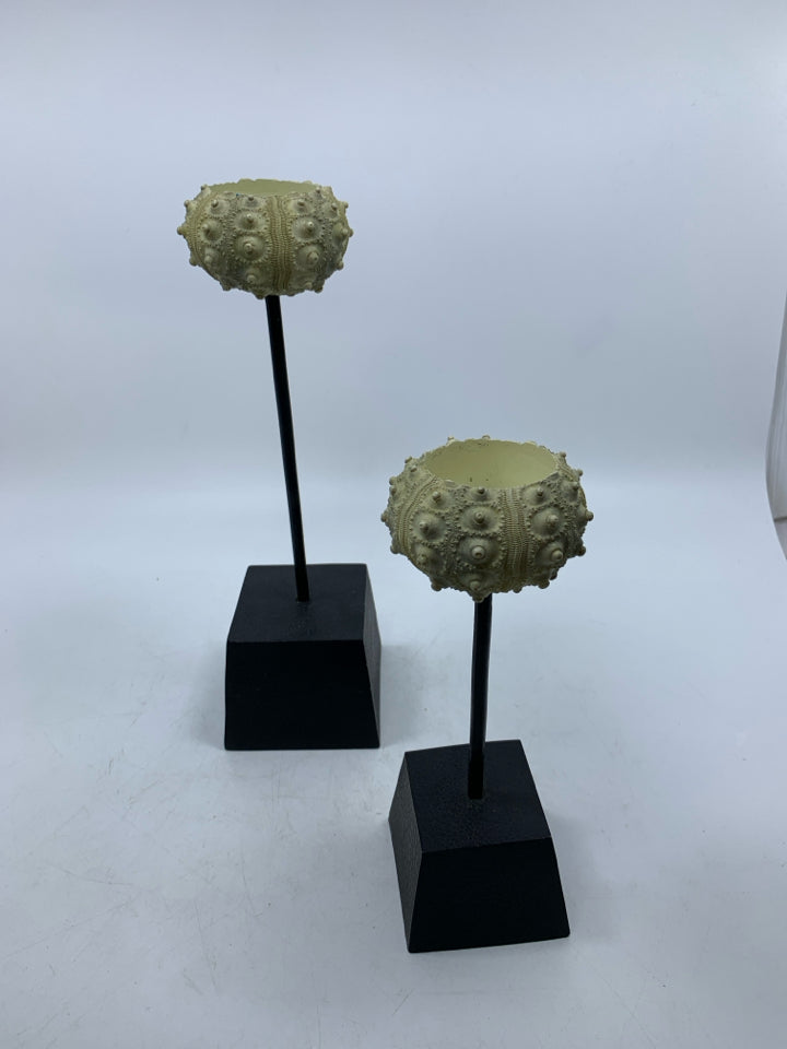 2 SHELL LOOK TEA LIGHT HOLDERS ON BLACK STANDS.
