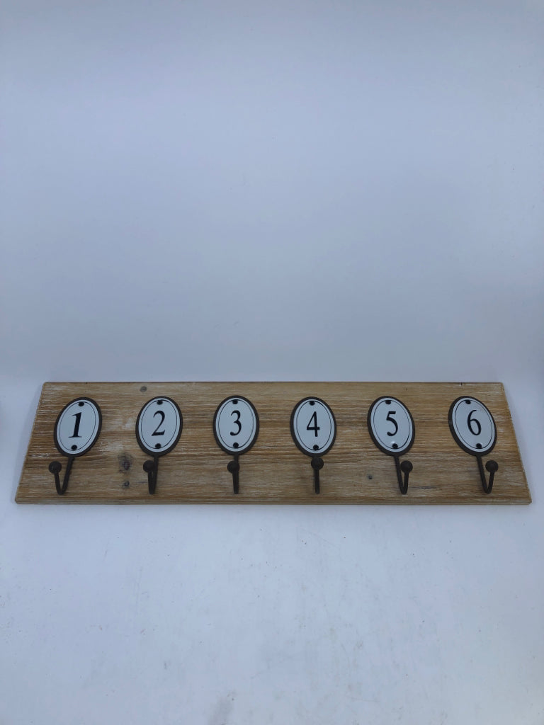 NUMBERED HOOKS ON WOOD WALL ART.