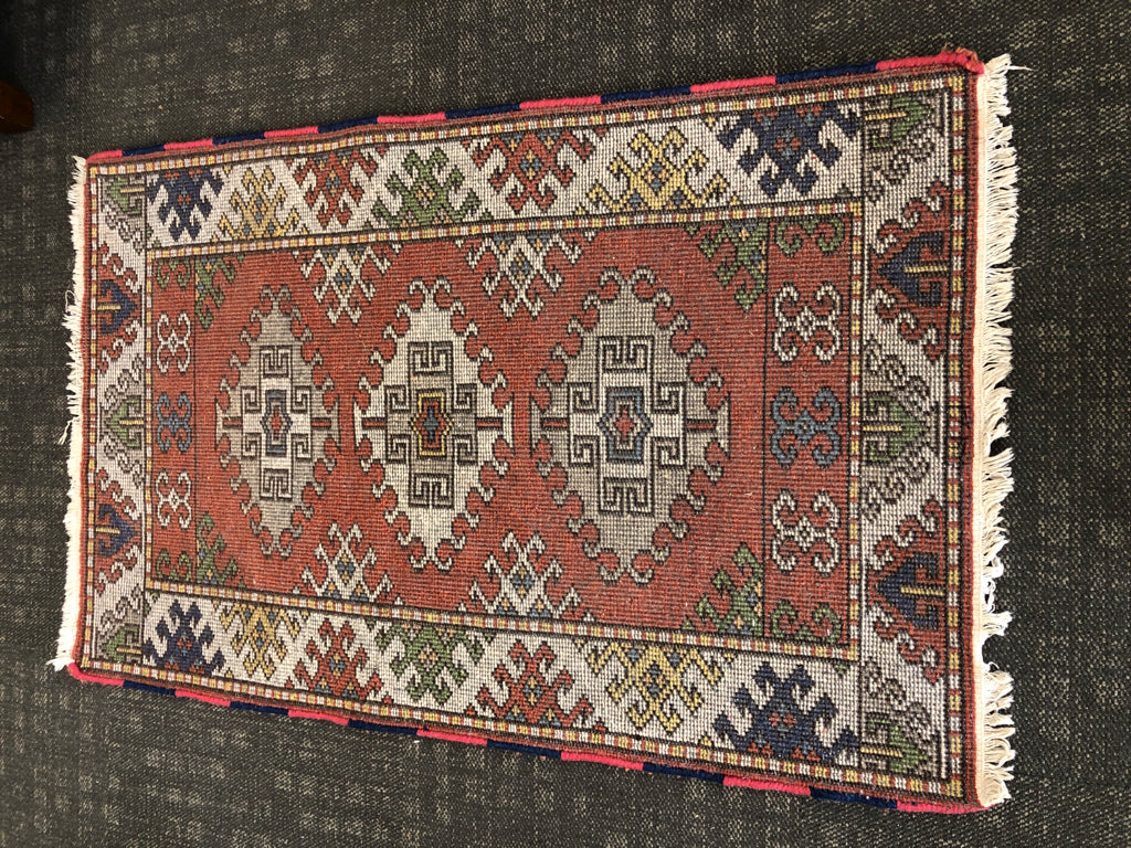 ORANGE ORIENTAL PATTERN RUG W/WHITE FRINGE.