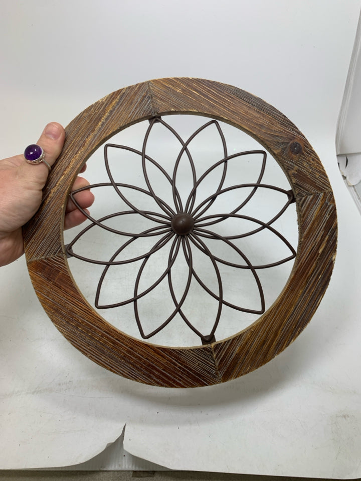 CIRCLE FRAME W/ METAL FLOWER IN CENTER.