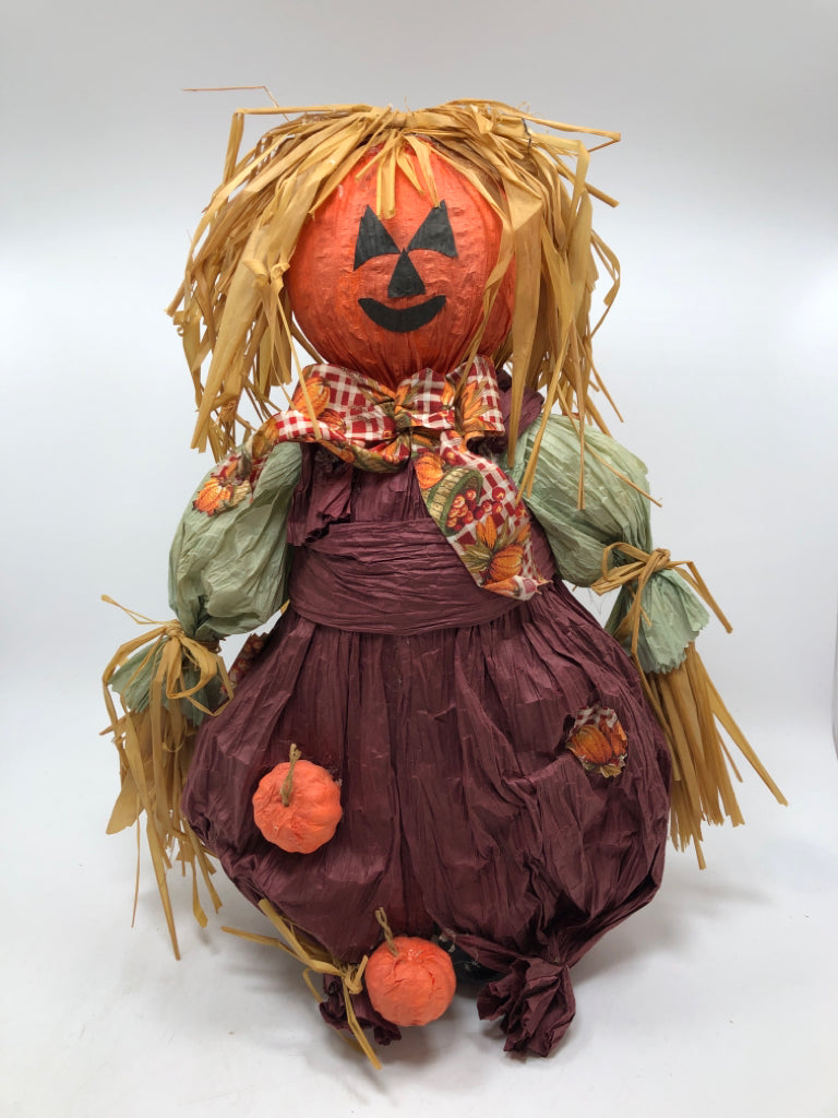 STRAW SCARECROW W/PURPLE OVERALLS.