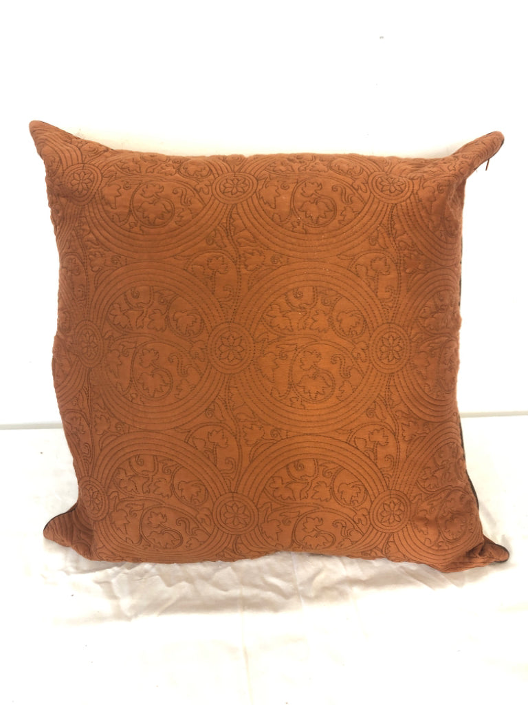 BURNT ORANGE PILLOW W/ STITCHED PATTERN.