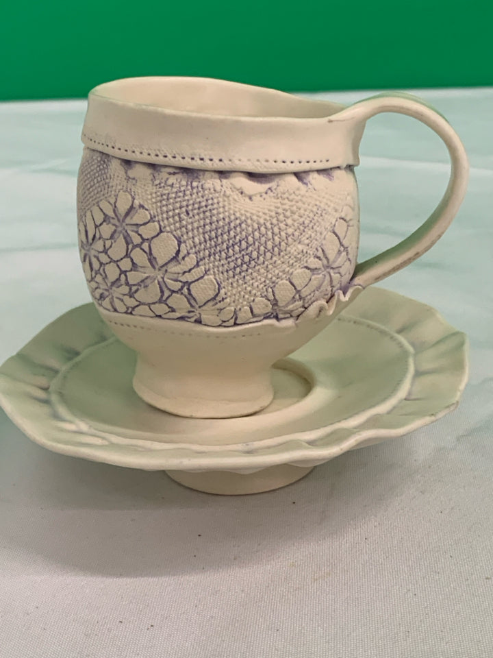 HANDMADE POTTERY EMBOSSED TEACUP AND SAUCER.