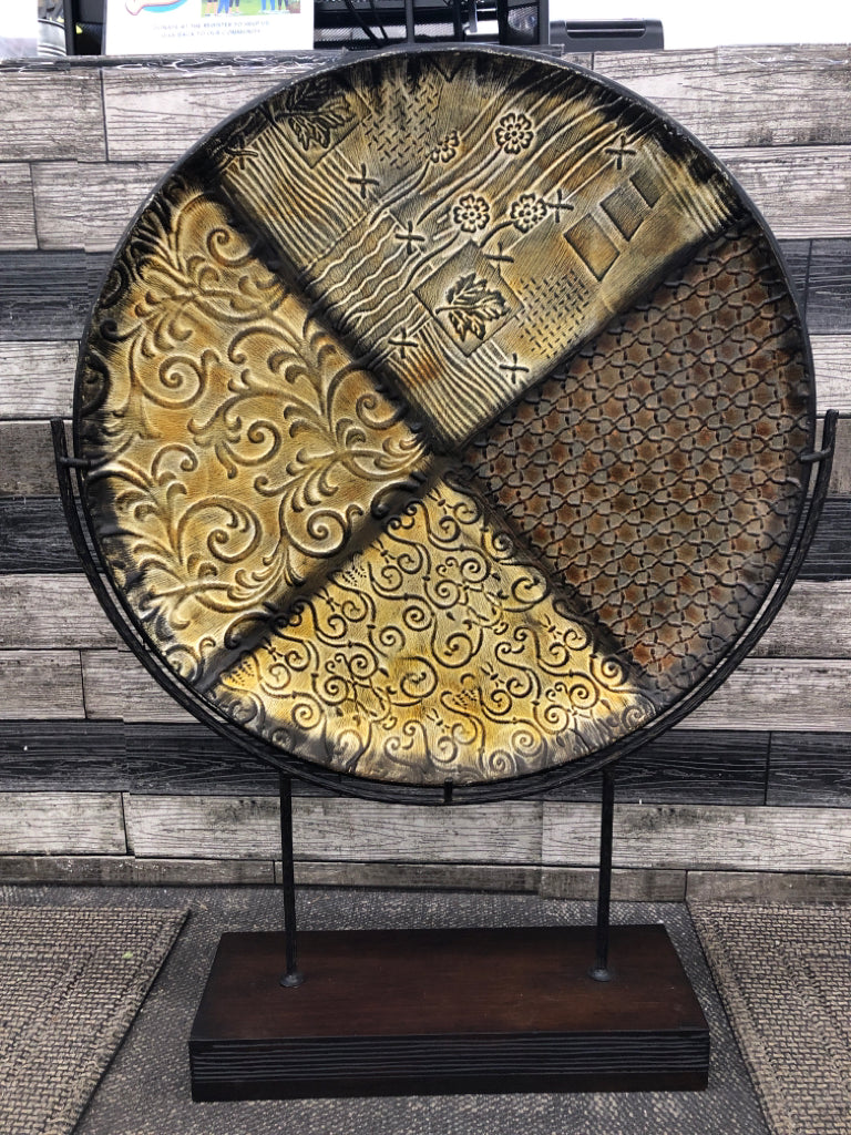 LEAF EMBOSSED ROUND METAL CENTERPIECE ON WOOD STAND.