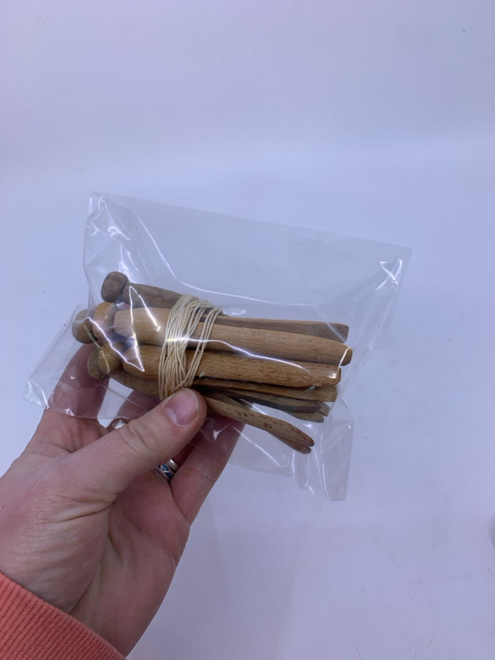 A BUNCH OF WOOD CLOTHES PINS IN BAG.