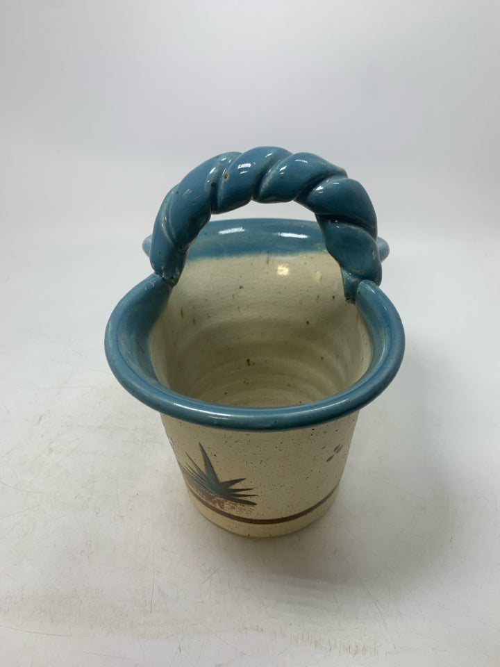 BASKET VASE W/ MOTHER/SON HOLDING HANDS LOOKING OUT LIGHT BLUE EDGES.