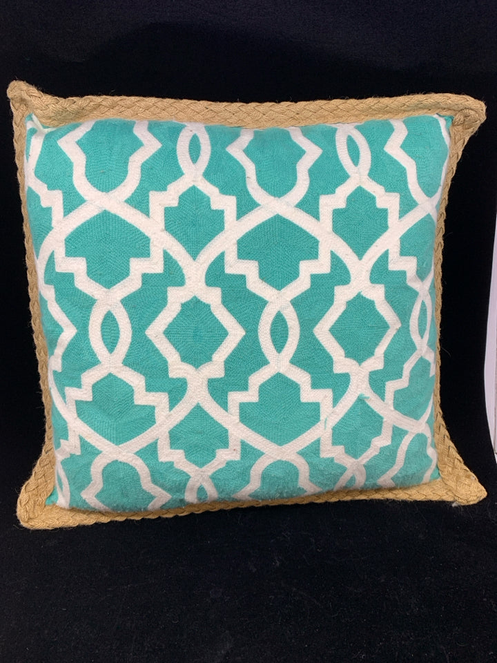 TEAL PILLOW W/WHITE DESIGN & BRAIDED BURLAP BORDER.
