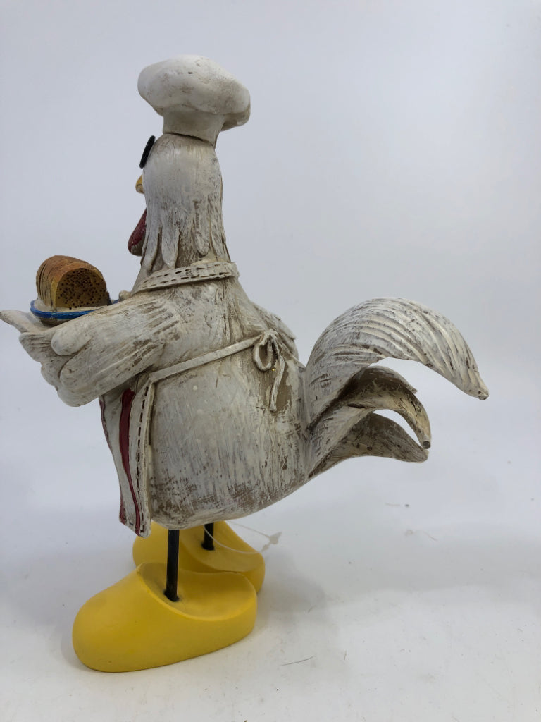 CHICKEN CHEF HOLDING BREAD W/LARGE SHOES.