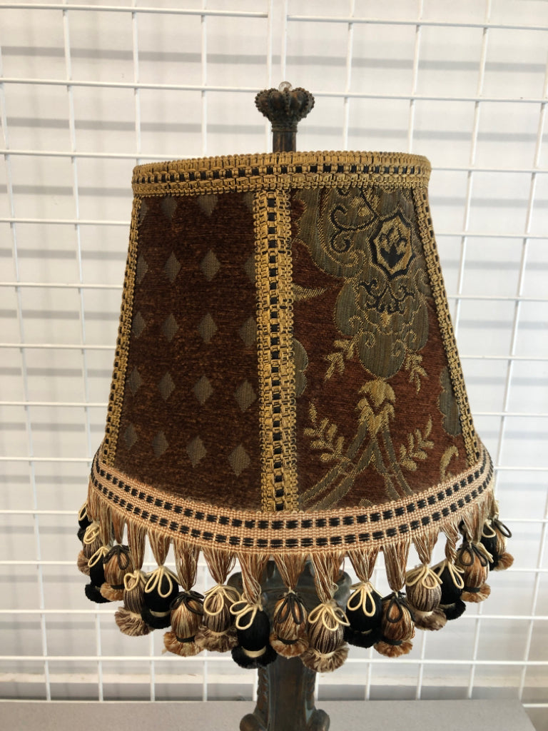 HEAVY LAMP W/SCROLL DISTRESSED BASE AND FABRIC SHADE W/TASSELS.