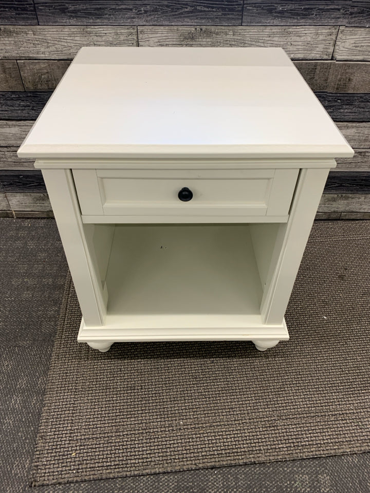 WHITE NIGHT STAND W/ DRAWER BLACK HARDWARE.