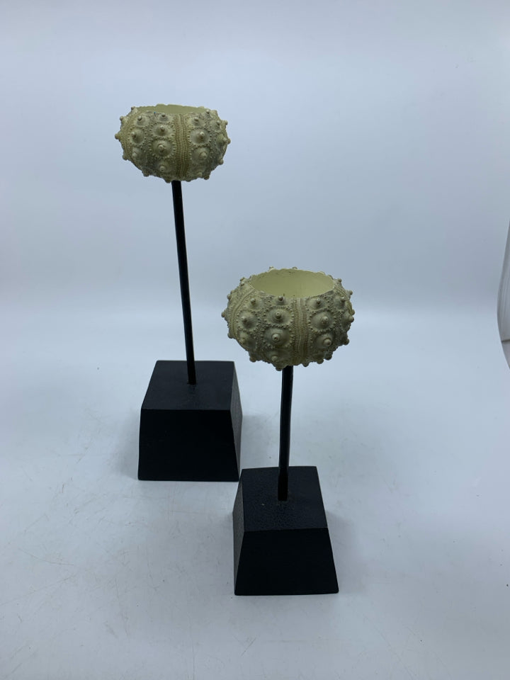 2 SHELL LOOK TEA LIGHT HOLDERS ON BLACK STANDS.