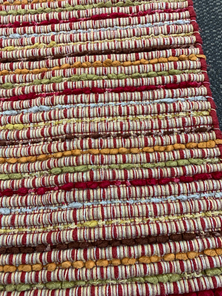 SMALL RED AND YELLOW PATTERN AREA RUG.