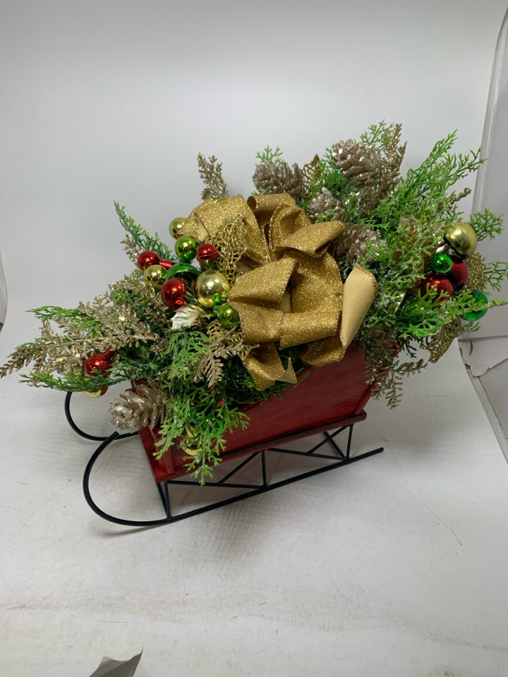 RED SLEIGH W/ HOLIDAY FLORAL ARRANGEMENT.