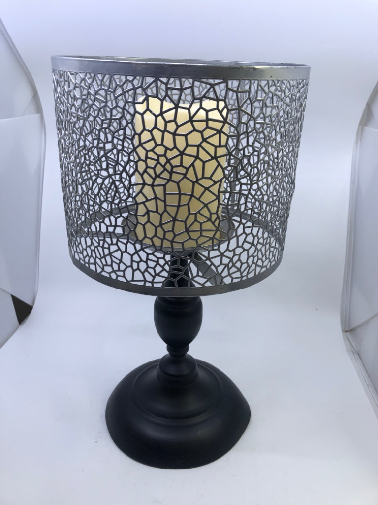 BLACK FOOTED PILLAR CANDLE HOLDER W/ GREY PIERCED METAL SHADE.