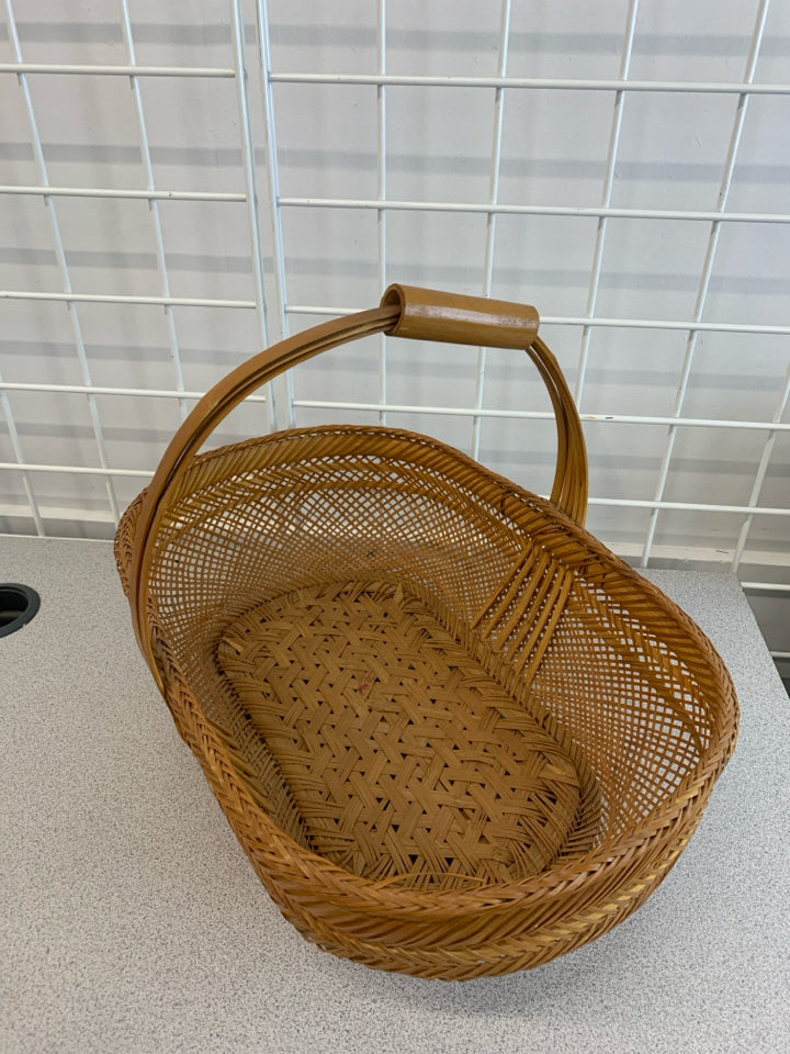 OVAL BROWN WOVEN BASKET W/TUBE HANDLE.