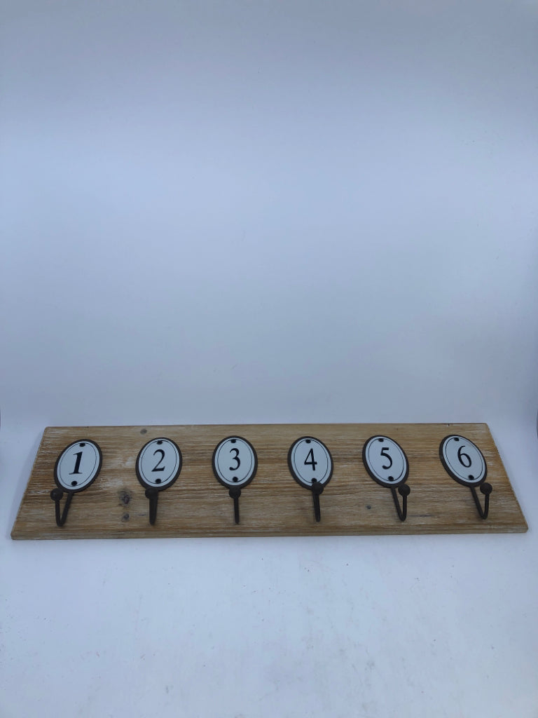 NUMBERED HOOKS ON WOOD WALL ART.