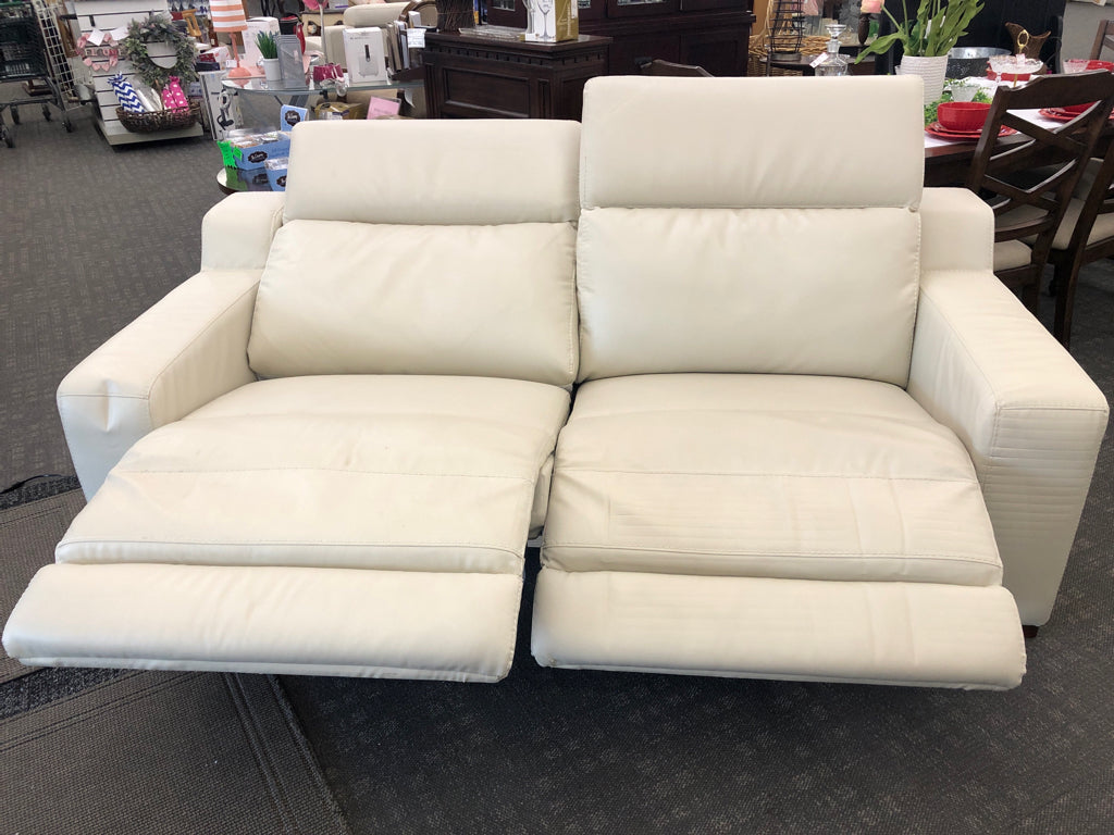 WHITE FAUX LEATHER RECLINING LOVE SEAT.