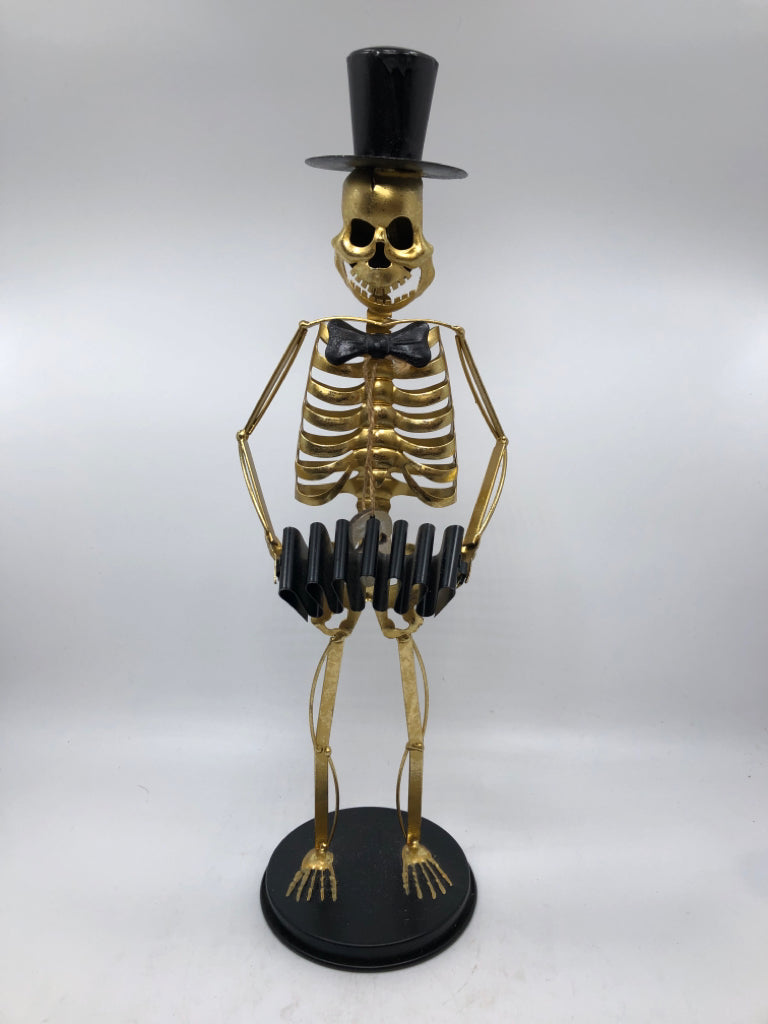 GOLD SKELETON SCULPTURE WITH TOP HAT AND ACCORDION.