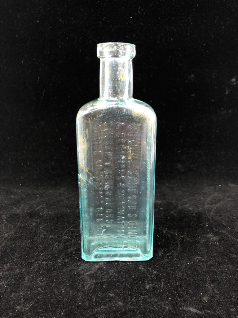 EMPTY LIGHT BLUE GLASS BOTTLE W/ WRITING.