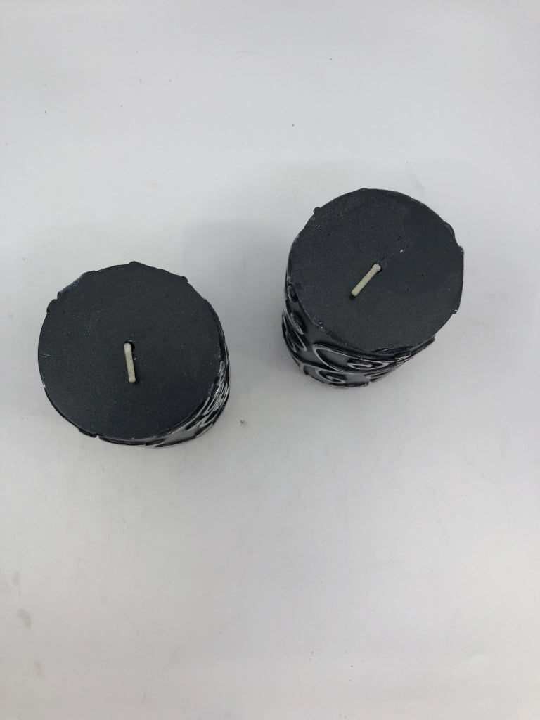 2 BLACK SCROLL PILLAR CANDLES.