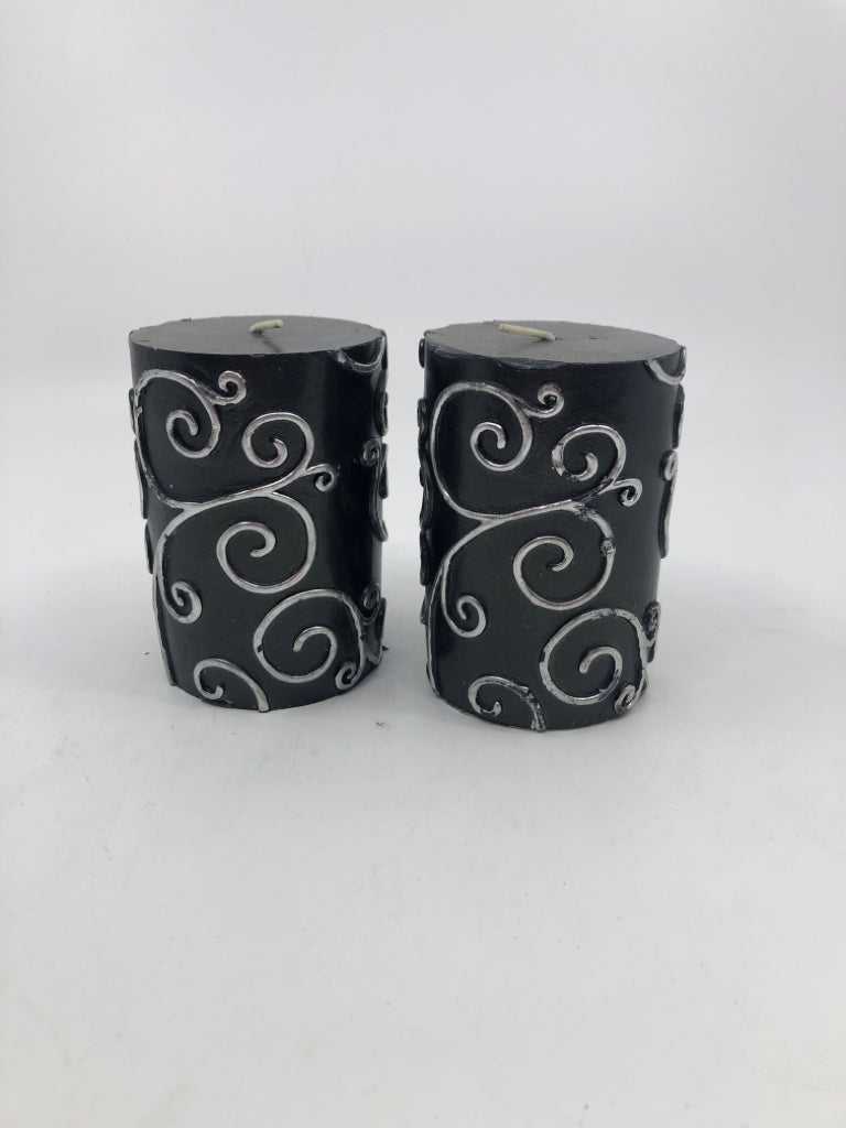 2 BLACK SCROLL PILLAR CANDLES.