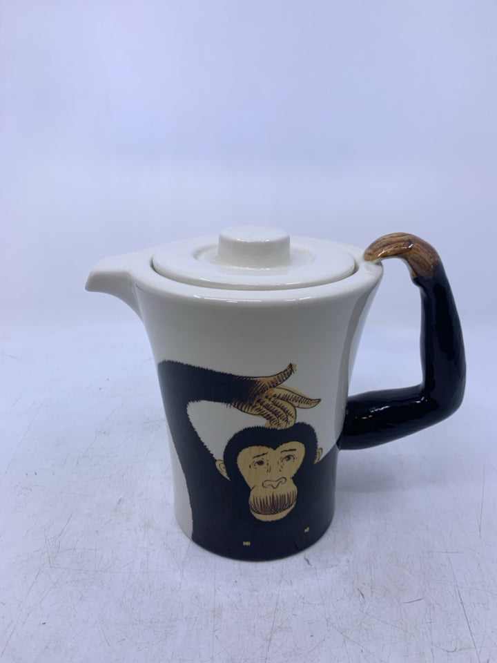 CREAM W/ MONKEY ON IT AND ARM AS HANDLE.