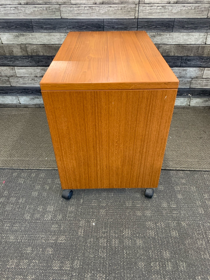 SMALL HEAVY WOOD DESK ON WHEELS W/ INSIDE SHELF.